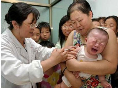 children being vaccinated - Chinese doctor vaccinates a crying Chinese baby in the arms of its mother