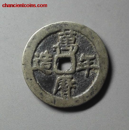 circular coin with four chinese characters on it and a square hole in the center