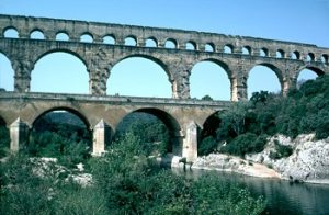 A roman aqueduct - stone arches across a river valley
