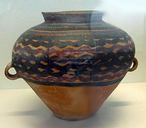 big jar with wavy black lines painted on it horizonatally
