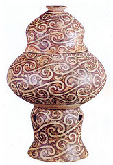 Cream colored vase with swirls of red from Neolithic Cucuteni