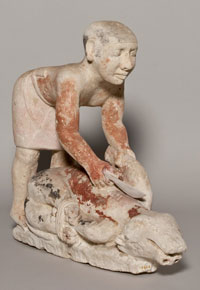 Wooden model of a man cutting the neck of a calf