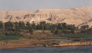 Nile river with dry cliffs in the distance