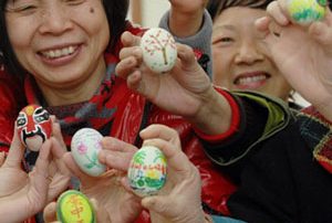 Chinese people holding painted eggs