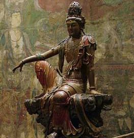 Kuan Yin statue of a woman sitting with one knee up and her arm resting on her knee