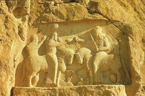 Rock carving in a cliff of two men on horseback fighting: the Sassanians