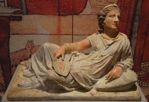 An Etruscan woman on her sarcophagus, holding a hand fan shaped like a leaf
